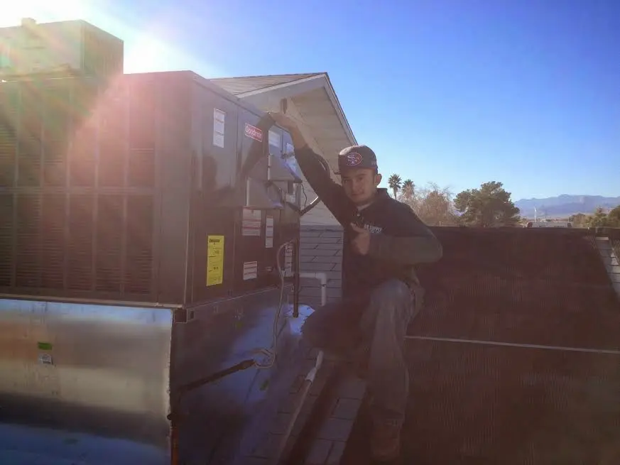 HVAC technician performing Heat Pump Repair on a rooftop unit in Lancaster